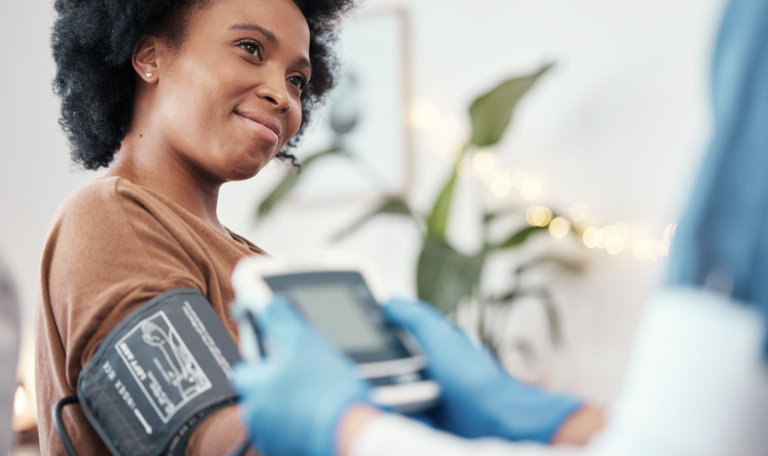 Nurse providing post-op care at home by checking patient vitals during recovery